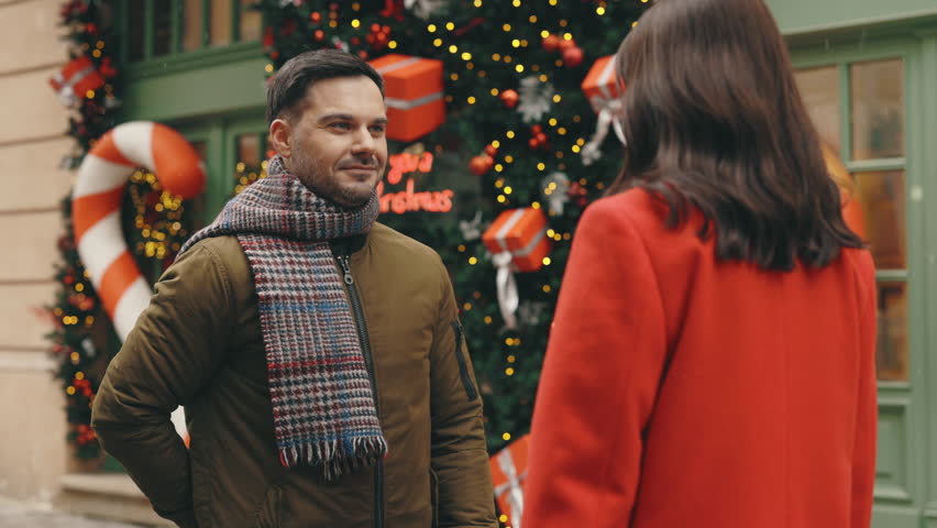 Handsome man is making a surprise proposal of marriage to his beloved woman in the winter decorated street. The woman is accepting emotionally and giving a hug full of love | Shutterstock HD Video #1111491161