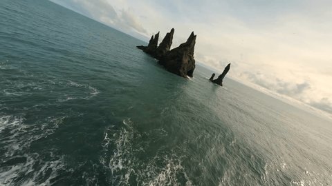 Flying with FPV drone over the Reynisdrangar sea stacks in the Atlantic Ocean near Vík, Iceland : vidéo de stock