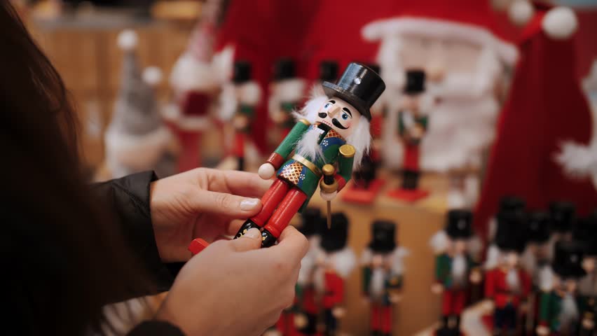 Nutcracker toy, soldier. Christmas shopping. Fair. close-up. woman chooses Christmas festive accessories and decorations in the shop. Merry Christmas and Happy New Year. shopping mall 