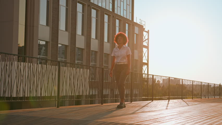 Female silhouette in sunshine city outdoors urban happy carefree winner African American business woman walking jumping celebrate win achievement victory triumph jump success joyful girl businesswoman Royalty-Free Stock Footage #1111495185