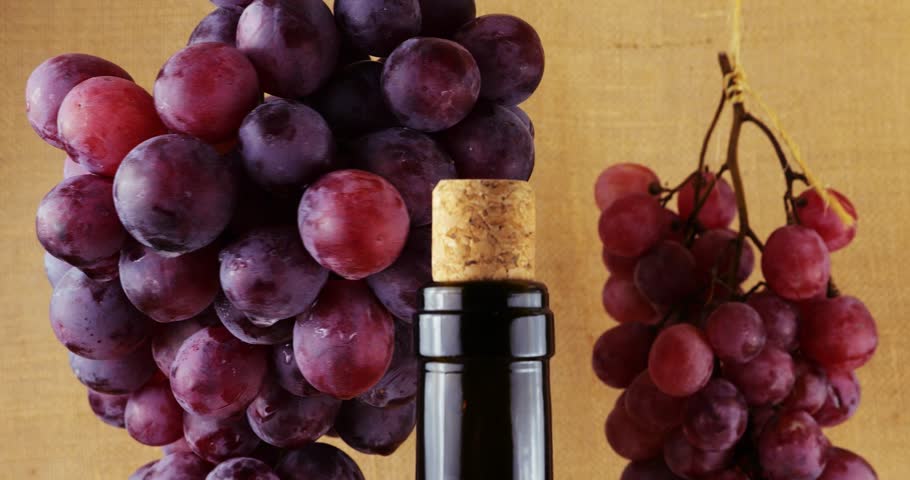 Grapes and bottles of wine on a burlap background.