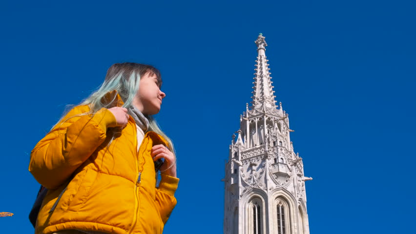 Girl enjoy matthias church. A pretty blue haired girl enjoy the budapest cathedral in the sun light.