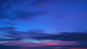 Sunrise Time-lapse: The sky transforms from inky darkness to a riot of fiery oranges and pinks. Wispy clouds dance across the horizon, painting the dawn with an ethereal glow. Timelapse. 4K.
