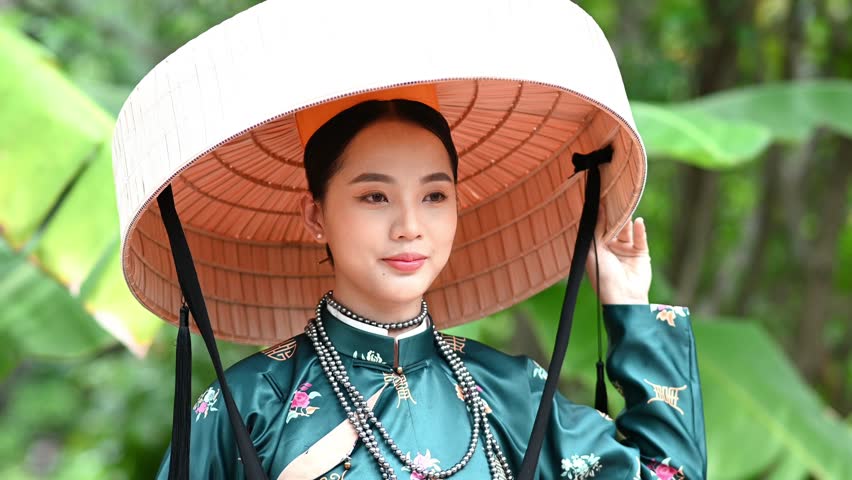 A young girl is wearing Vietnamese traditional style clothes, Nguyen Dynasty, Tran Dynasty. Video for tourism, culture, tradition, and the beauty of Asian people