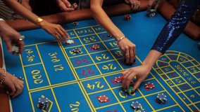 Anonymous Group of Rich Men and Women Gathered Around a Roulette Table at a Modern Casino. Cinematic Close Up Footage of Gambler Hands Placing Bets while the Ball Spinning in a Roulette Wheel - Powered by Shutterstock - Get 15% off with code: PIKWIZARD15
