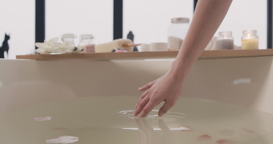 close up view of woman hands touching water of a bathtub with flowers. Royalty-Free Stock Footage #1111521699