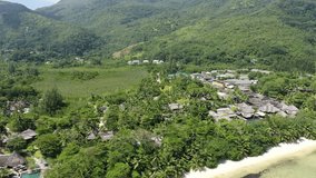 Aerial video above a residential area on the Seychelles coastline on a sunny day