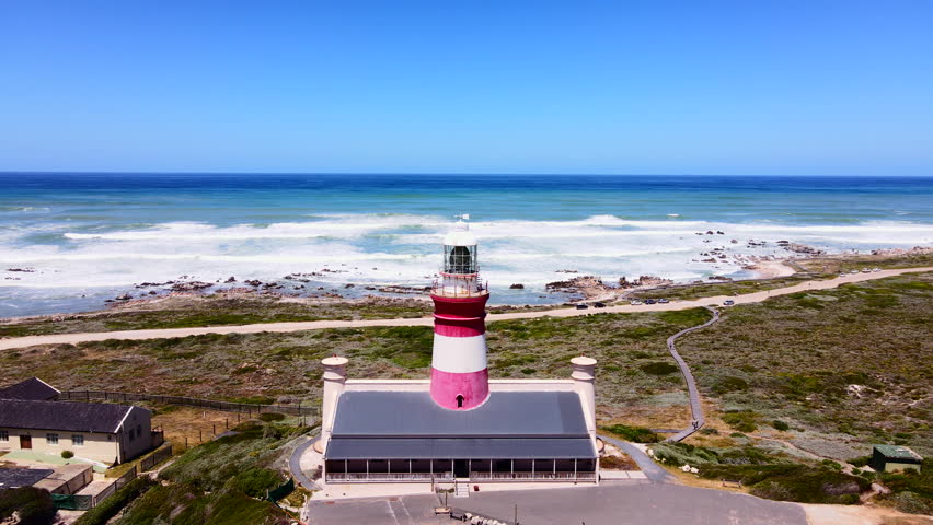 Famous Cape Agulhas lighthouse on Overberg coastline, South Africa. Aerial Royalty-Free Stock Footage #1111523307