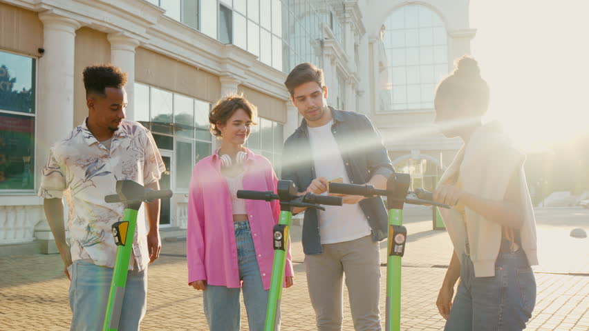 Multiracial friends communicate with each other before riding shared electric push scooters in the city. Rental electric transportation. | Shutterstock HD Video #1111524011