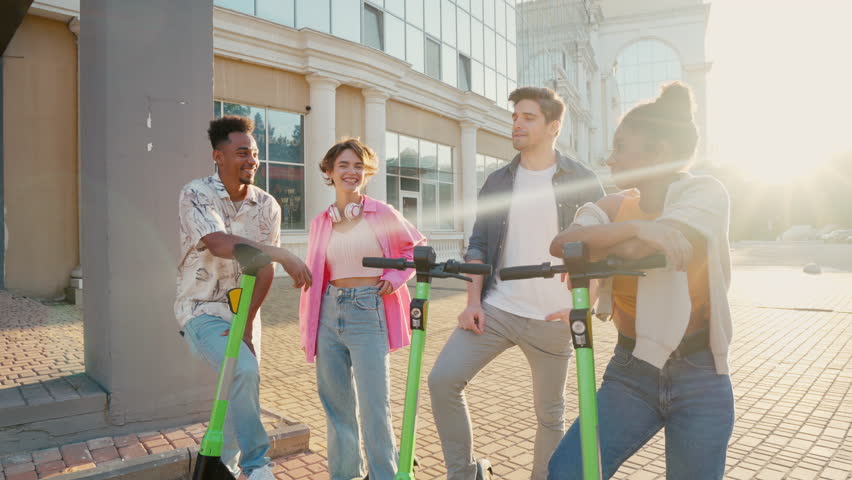 Multiracial friends communicate with each other before riding shared electric push scooters in the city. Rental electric transportation. | Shutterstock HD Video #1111524013