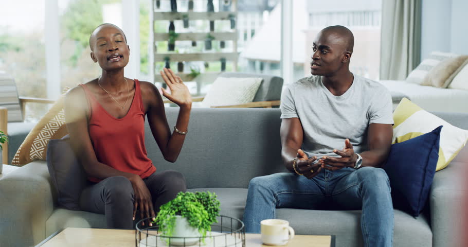 Divorce, stress and couple on a sofa fighting, angry or frustrated in their home together. Marriage, conflict and black woman annoyed with man liar in a living room with communication fail or dispute | Shutterstock HD Video #1111525441