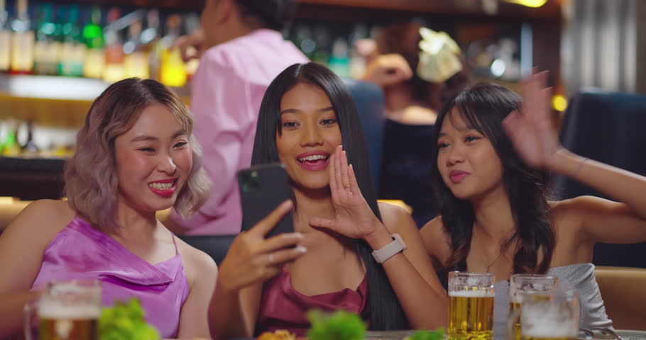 Beautiful young asian woman using phone and taking selfie with friend in bar. They Enjoying with Night Party Together. Party, Lifestyle, Happiness, Cheerful and Celebration Concept. | Shutterstock HD Video #1111527621