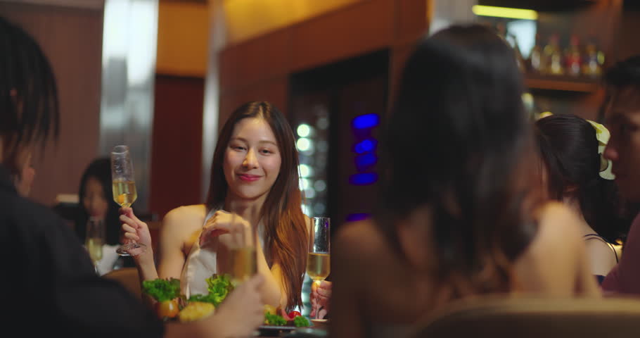 Beautiful Asian woman is Relishing a Delightful Dinner with Friends at a Bar, Immersed in the Joy of a Vibrant Night Party. They Enjoying with Night Party Together. Party and Celebration Concept. | Shutterstock HD Video #1111527623