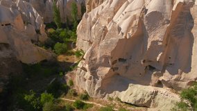 Embark on a visual journey with this mesmerizing aerial stock video capturing the essence of Cappadocia's cave dwellings near Goreme, Turkey. The bird's eye perspective unveils the unique charm of