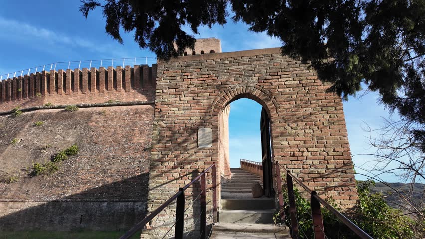 walls of Brisighella Castle, referred to as Rocca Manfrediana, as viewed from below, stand as testament to 14th-century fortification architecture in Italy. medieval and thermal hamlet of Brisighella.