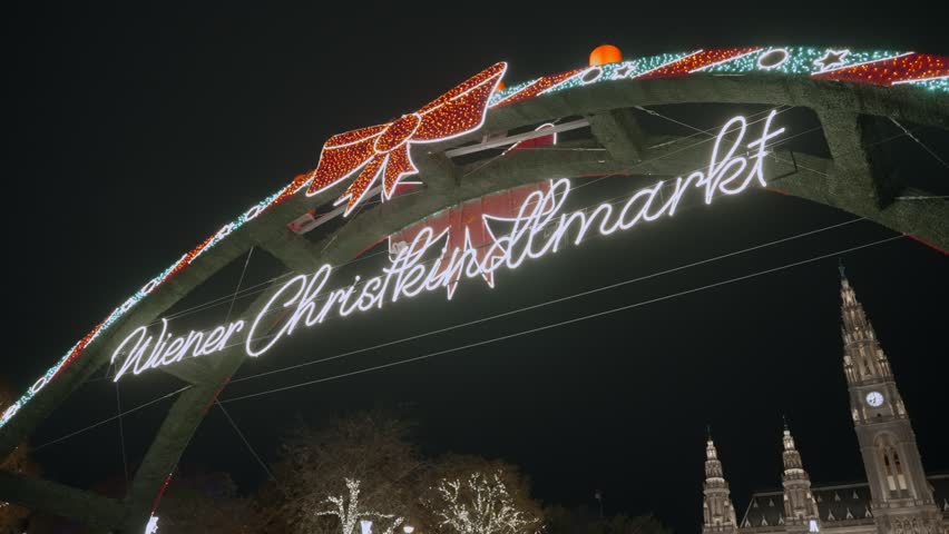 Illuminated entrance sign for the Vienna Christmas market and fair during season. Fun and festive celebrations with traditional food and drinks. Tourists and residents visit at winter time in Austria