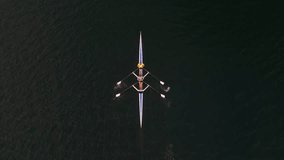 Top View shot drone Sports Rowing Boat with a Crew of Young Sportsmen. Sport Canoe Being Driven by a Team of Young Women and Men in an Ocean Bay with a Beautiful Sunrise, Nova Scotia, Halifax. Canada. - Powered by Shutterstock - Get 15% off with code: PIKWIZARD15