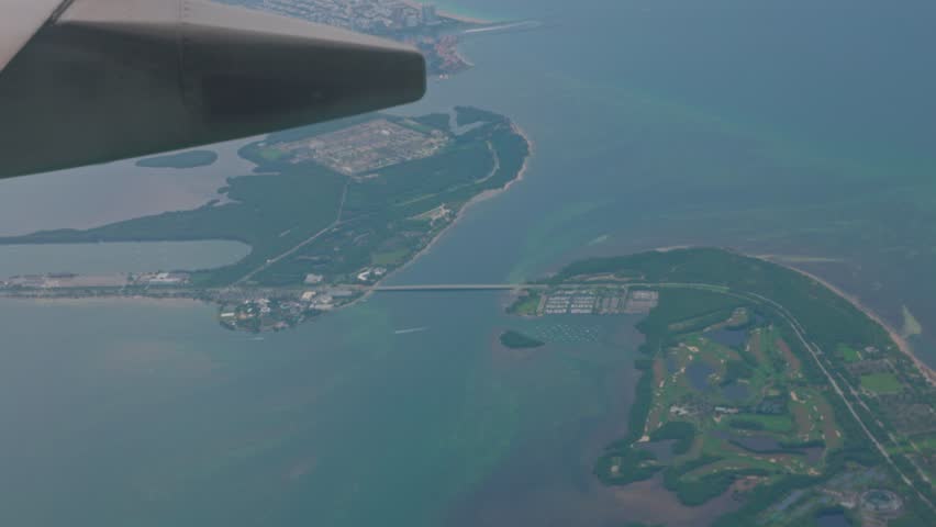 During airplane's descent for landing view unfolds from window, showcasing blue waters of Atlantic Ocean and cityscape of Miami.  | Shutterstock HD Video #1111543283