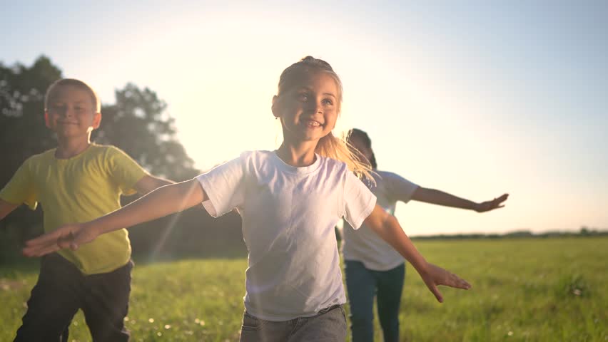 Children run in meadow. happy family childhood dream concept. several children run on the grass in summer and have fun together. kids run in the meadow lifestyle with green grass at sunset | Shutterstock HD Video #1111547373