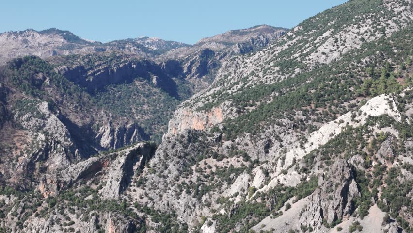 Exposed white grey rocks dotted with low shrubs in Taurus mountains Turkey