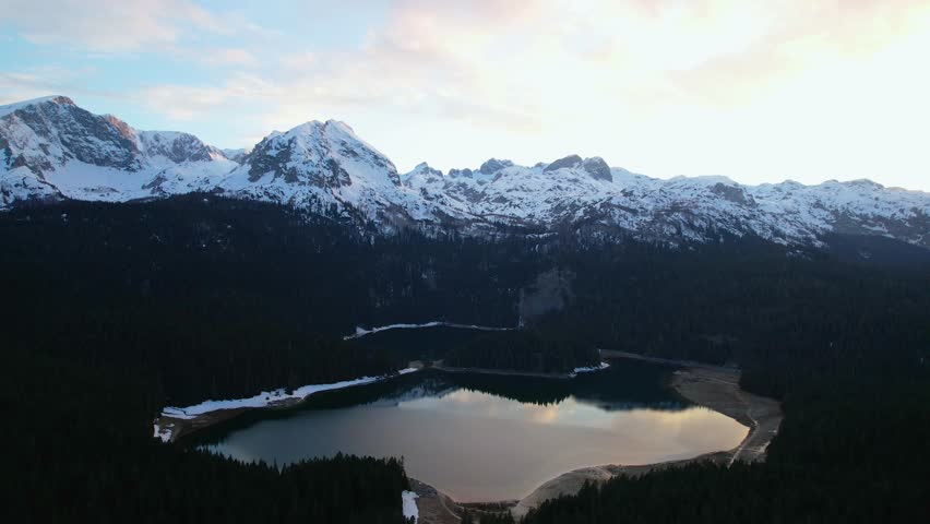 Aerial views of the forests around the Black Lake located among the Durmitor Mountains under snow
