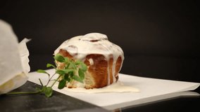cooked baked sweet cinnabon with cream on black background