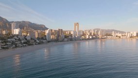 Aerial drone video of the coastal town named Benidorm. Benidorm is a tourism destination in the Costa Blanca. High apartment buildings fill the coastline in the Spanish province of Alicante.