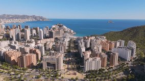 Aerial drone video of the coastal town named Benidorm. Benidorm is a tourism destination in the Costa Blanca. High apartment buildings fill the coastline in the Spanish province of Alicante.