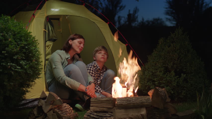 Mom and Son Bonding Sitting in Tent by the Fire. Family enjoying camping evening together. | Shutterstock HD Video #1111571923