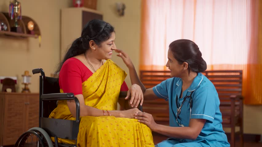 Joyful Indian nurse building confidence or encouraging recovered sick woman on wheelchair at home - concept of rehabilitation, hopeful assistance and motivation Royalty-Free Stock Footage #1111574061