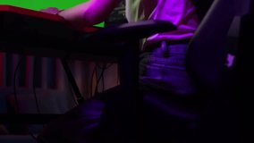 Close Up Back View Of Asian Girl Streamer Playing Game, Touching, And Swiping Experience Virtual Reality In Futuristic Goggles. Green Screen Personal Computer On Desk 