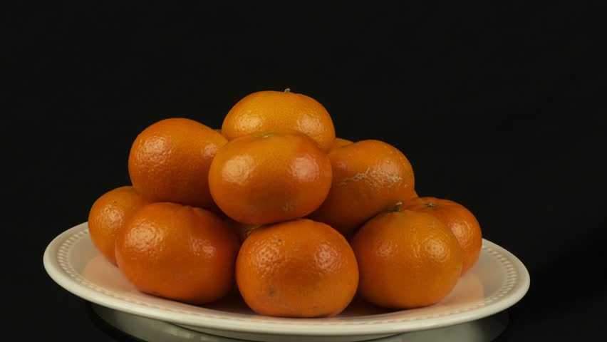 Orange pyramid of Mandarin Clementine fruit rotates on white plate - Powered by Shutterstock - Get 15% off with code: PIKWIZARD15