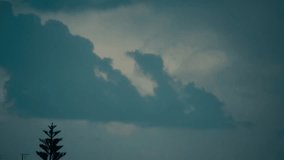 A scenic shot of a flying airplane between sliding clouds, dark blue sky, stormy weather, middle east Tel Aviv, Israel, moving tree, Sony 4K video