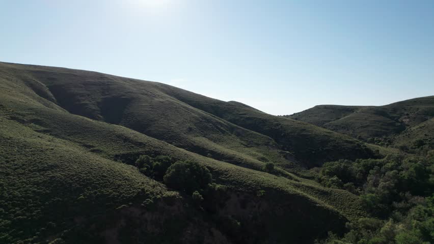 Dramatic sloping mountain hills against bright blue sky in Lemnos