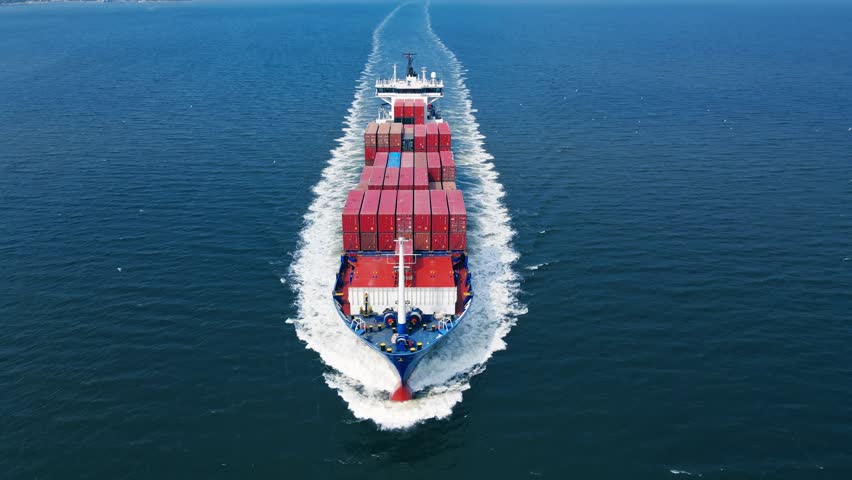 Aerial drone shot above huge container carrier ship cruising ocean sea, sea transport logistics carriage