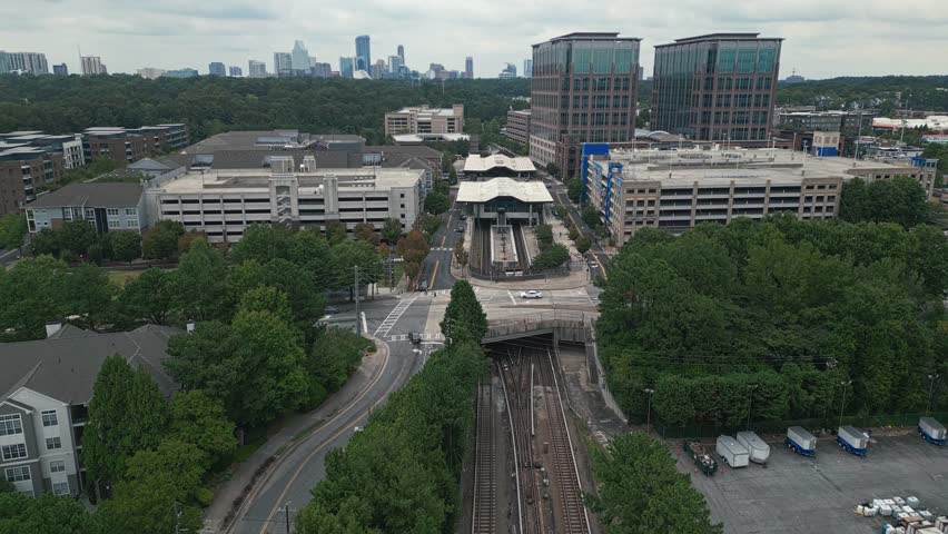 Aerial approaching shot of Lindbergh Marta Station wit Atlanta Downtown in background 