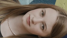 Close up portrait of confident girl posing near dotted wall - vertical video, provo, utah, united states - Powered by Shutterstock - Get 15% off with code: PIKWIZARD15