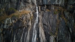 Experience the awe-inspiring beauty of nature with this captivating 4K aerial video capturing the powerful and graceful descent of a cascading waterfall. Immerse yourself in the mesmerizing sights.