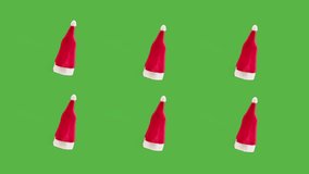 Christmas new year red hats rotating on green chroma key backgroung close up, vibes of winter holidays.  - Powered by Shutterstock - Get 15% off with code: PIKWIZARD15