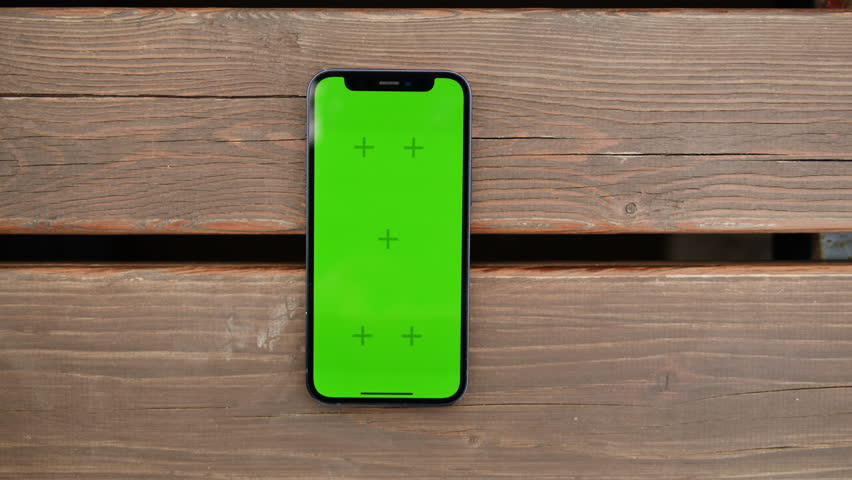 Phone with chroma key screen on the wooden background close-up. Green screen on smart phone. Nature | Shutterstock HD Video #1111589847