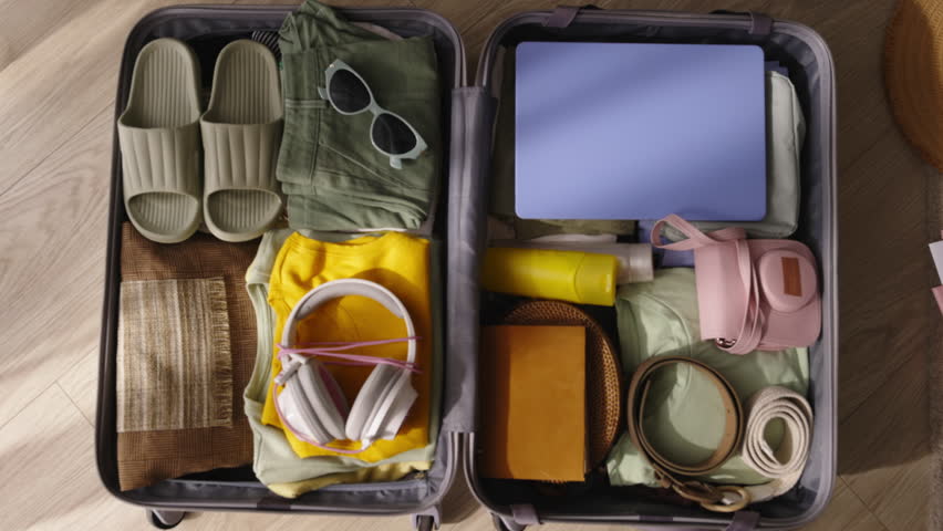 Packing suitcase top view. Video no people. Bonuses of remote work - life on beach. Taking on work in another country, opportunity for new career and lifestyle, exciting journey endless possibilities | Shutterstock HD Video #1111591685
