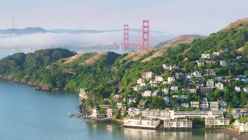 Aerial view of Sausalito landscape with cute houses at the Pacific Ocean, San Francisco area, California, West coast, USA. Breathtaking shot of San Francisco suburban with Golden Gate bridge in fog