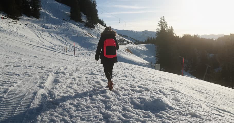 Young woman walking on snow mountain track during winter time at sunset - Travel and landscape nature concept  | Shutterstock HD Video #1111597229