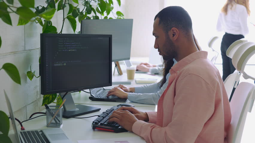 Multi Ethnic Computer Programmer Writing a Code in an Office. Guy Software Developer Sitting and Working on a Laptop. Creative Business Man Working in a Tech Company | Shutterstock HD Video #1111602825