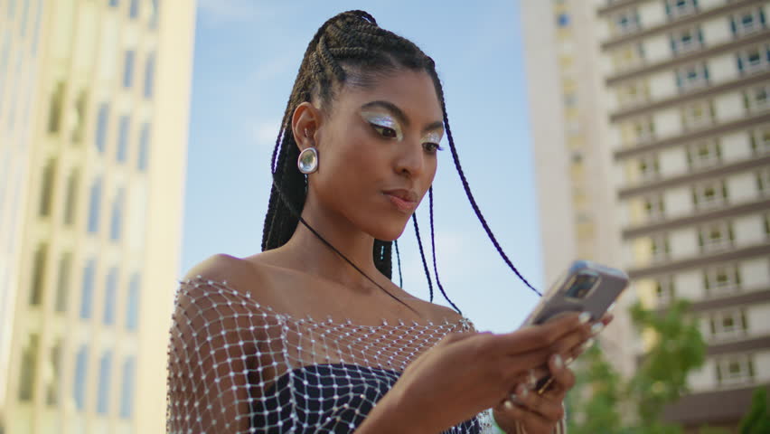 Trendy woman talking phone loudspeaker at summer street closeup. Stylish african american lady recording voice message on smartphone microphone using mobile assistant app. Modern technology concept  | Shutterstock HD Video #1111603669