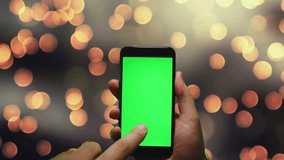 a green screen smartphone in man hand in Christmas background for advertising and ads .
