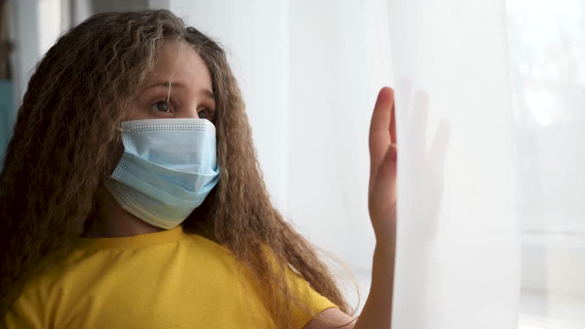 Happy family concept.baby in home quarantine.child at home in isolation wearing protective mask looks out window.baby stands at window and waves his hand.sad child wearing mask at home in quarantine Royalty-Free Stock Footage #1111608423