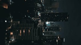 Cinematic nighttime cityscape with towering skyscrapers, aerial view. Vertical video. Big city at night, with iconic skyscrapers. Atmosphere of nocturnal cityscape with modern buildings of metropolis.