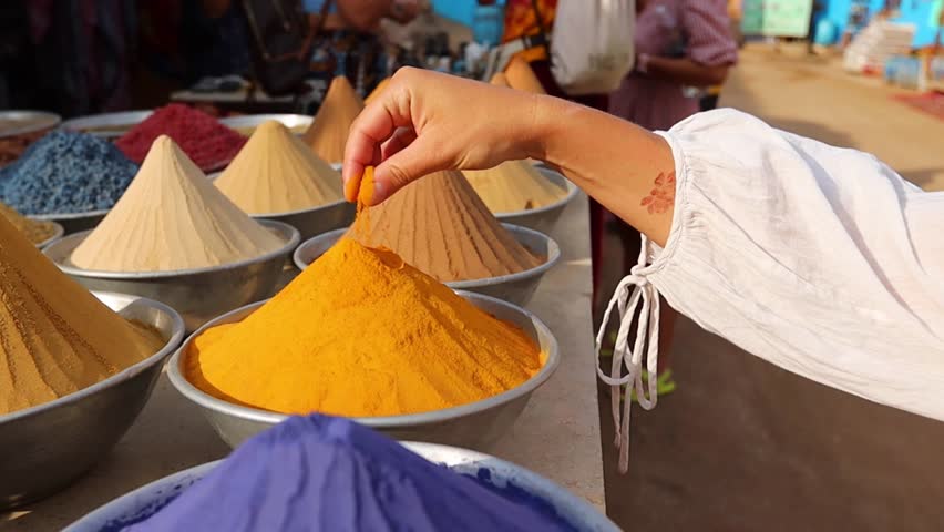 Woman hand touching Pyramid of spices on Egyptian market in Aswan Egypt
