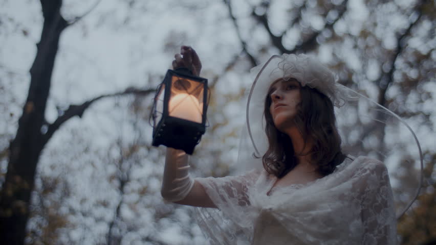 A Woman in white dress holding an old lantern